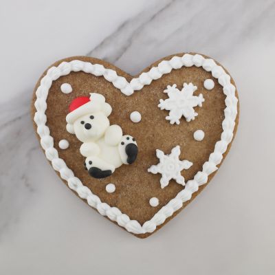 Eisbär mit Weihnachtsmütze auf Lebkuchenherz
