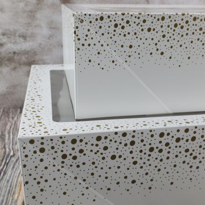 weißer Tortenkarton mit goldenen Punkten